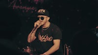 a man is singing into a microphone in front of a crowd